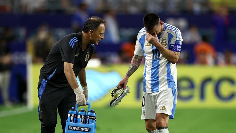 Pemain Argentina Lionel Messi duduk di bangku cadangan setelah meninggalkan lapangan karena cedera saat pertandingan sepak bola final Copa America melawan Kolombia di Miami Gardens, Fl., Minggu, 14 Juli 2024. (AP Photo/Julio Cortez)