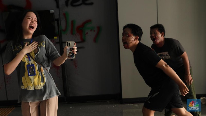 Seniman berkostum zombie menakuti penumpang LRT Jakarta di Stasiun Pegangsaan Dua Jakarta, Senin, (15/7/2024). (վ/Muhammad Sabki)