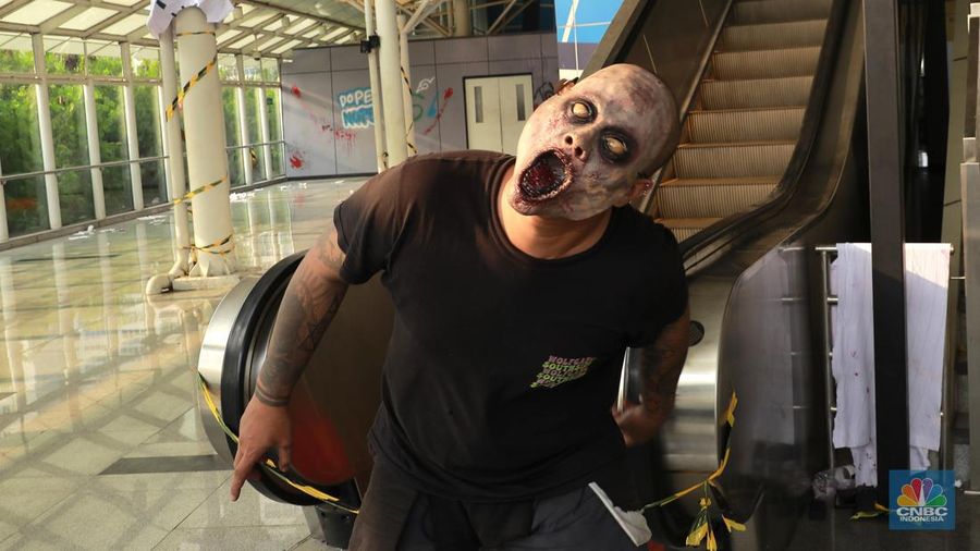Seniman berkostum zombie menakuti penumpang LRT Jakarta di Stasiun Pegangsaan Dua Jakarta, Senin, (15/7/2024). (վ/Muhammad Sabki)
