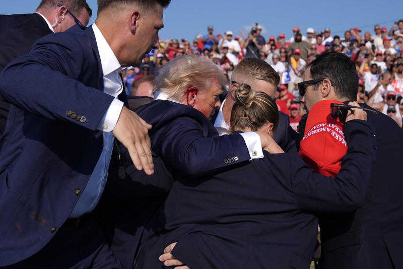 Kandidat presiden dari Partai Republik mantan Presiden Donald Trump dikelilingi oleh agen Dinas Rahasia AS saat ia meninggalkan panggung pada rapat umum kampanye, Sabtu, 13 Juli 2024, di Butler, Pa. (AP Photo/Evan Vucci)