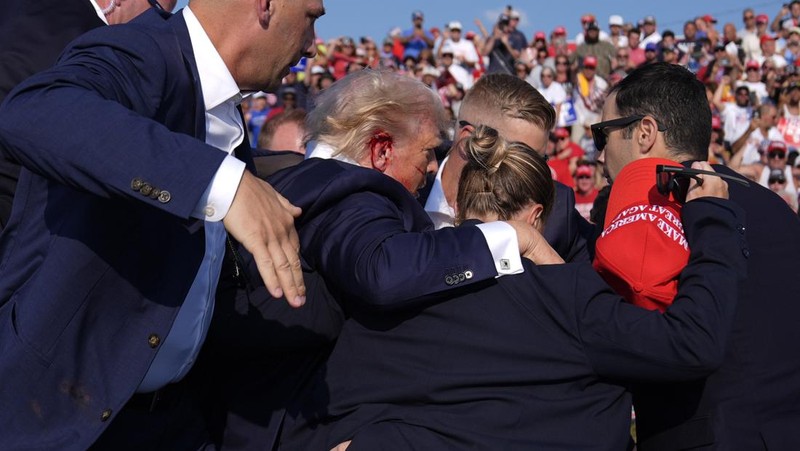 Kandidat presiden dari Partai Republik mantan Presiden Donald Trump dikelilingi oleh agen Dinas Rahasia AS saat ia meninggalkan panggung pada rapat umum kampanye, Sabtu, 13 Juli 2024, di Butler, Pa. (AP Photo/Evan Vucci)