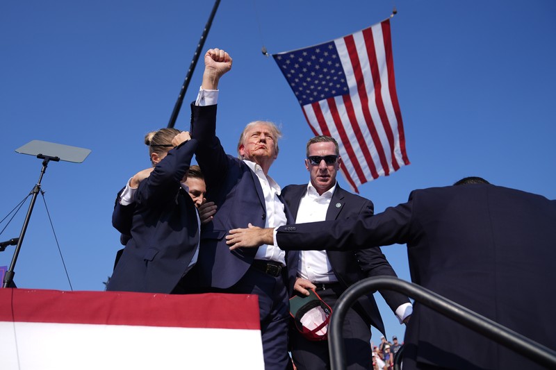 Kandidat presiden dari Partai Republik mantan Presiden Donald Trump dikelilingi oleh agen Dinas Rahasia AS saat ia meninggalkan panggung pada rapat umum kampanye, Sabtu, 13 Juli 2024, di Butler, Pa. (AP Photo/Evan Vucci)