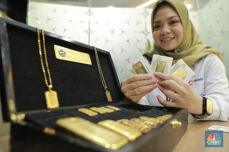Karyawati menunjukkan emas PT Aneka Tambang Tbk. (Antam) di salah satu gallery penjualan emas di Jakarta, Selasa (16/7/2024). (CNBC Indonesia/Muhammad Sabki)