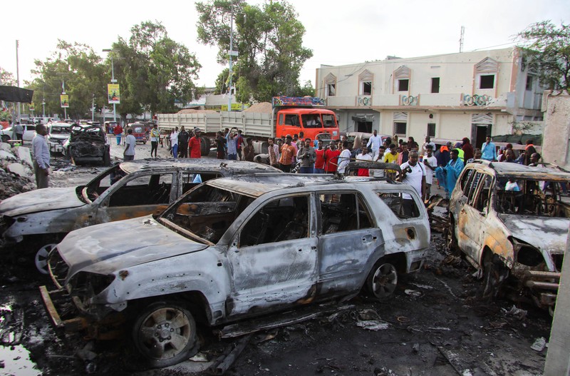 Orang-orang berkumpul di dekat puing-puing kendaraan yang hancur di lokasi ledakan di luar sebuah restoran tempat pengunjung menonton final turnamen sepak bola Euro 2024 di TV, di distrik Bondhere, Mogadishu, Somalia, 15 Juli 2024. Orang-orang berkumpul di dekat puing-puing kendaraan yang hancur di lokasi ledakan di luar sebuah restoran tempat pengunjung menonton final turnamen sepak bola Euro 2024 di TV, di distrik Bondhere, Mogadishu, Somalia, 15 Juli 2024. (REUTERS/Feisal Omar)
