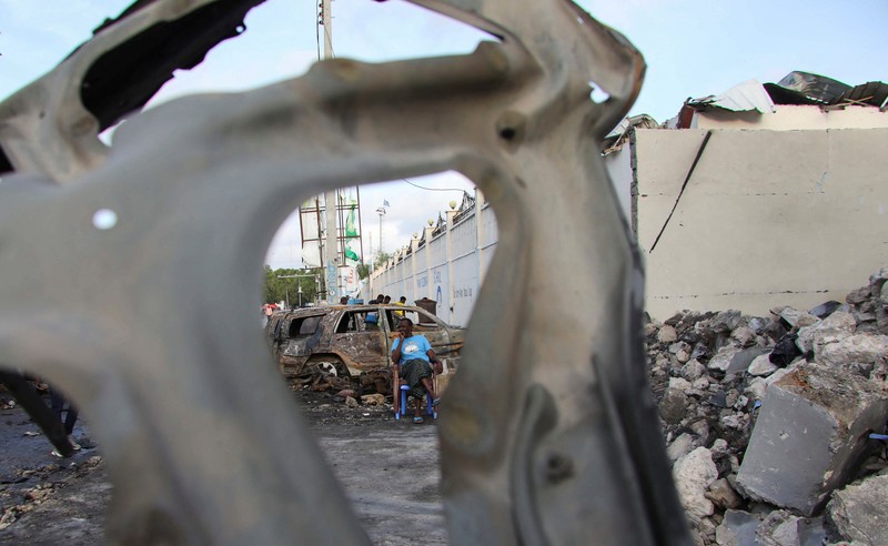 Orang-orang berkumpul di dekat puing-puing kendaraan yang hancur di lokasi ledakan di luar sebuah restoran tempat pengunjung menonton final turnamen sepak bola Euro 2024 di TV, di distrik Bondhere, Mogadishu, Somalia, 15 Juli 2024. Orang-orang berkumpul di dekat puing-puing kendaraan yang hancur di lokasi ledakan di luar sebuah restoran tempat pengunjung menonton final turnamen sepak bola Euro 2024 di TV, di distrik Bondhere, Mogadishu, Somalia, 15 Juli 2024. (REUTERS/Feisal Omar)