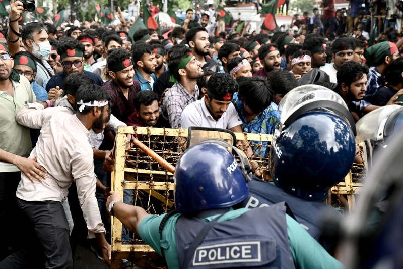 Aktivis mahasiswa mendorong barikade polisi selama unjuk rasa sebelum mereka menyerahkan memorandum mereka kepada Presiden mengenai reformasi kuota untuk pekerjaan pegawai negeri, di Dhaka pada 14 Juli 2024. (Photo by MUNIR UZ ZAMAN / AFP)
