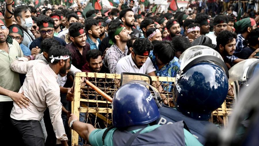 Aktivis mahasiswa mendorong barikade polisi selama unjuk rasa sebelum mereka menyerahkan memorandum mereka kepada Presiden mengenai reformasi kuota untuk pekerjaan pegawai negeri, di Dhaka pada 14 Juli 2024. (Photo by MUNIR UZ ZAMAN / AFP)