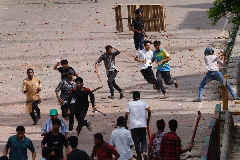 Aktivis mahasiswa mendorong barikade polisi selama unjuk rasa sebelum mereka menyerahkan memorandum mereka kepada Presiden mengenai reformasi kuota untuk pekerjaan pegawai negeri, di Dhaka pada 14 Juli 2024. (Photo by MUNIR UZ ZAMAN / AFP)