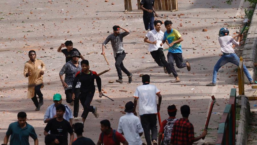 Aktivis mahasiswa mendorong barikade polisi selama unjuk rasa sebelum mereka menyerahkan memorandum mereka kepada Presiden mengenai reformasi kuota untuk pekerjaan pegawai negeri, di Dhaka pada 14 Juli 2024. (Photo by MUNIR UZ ZAMAN / AFP)