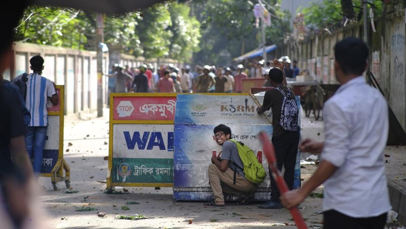 Aktivis mahasiswa mendorong barikade polisi selama unjuk rasa sebelum mereka menyerahkan memorandum mereka kepada Presiden mengenai reformasi kuota untuk pekerjaan pegawai negeri, di Dhaka pada 14 Juli 2024. (Photo by MUNIR UZ ZAMAN / AFP)