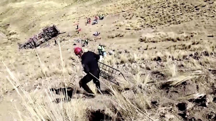 Mayat dan puing-puing tergeletak di lereng bukit di samping bus rusak yang jatuh ke jurang di lokasi terpencil di Andes, Peru, pada 16 Juli 2024. Sebuah bus jatuh ke jurang di Peru selatan, menewaskan sedikitnya 21 orang dan melukai 20 orang lainnya, kata polisi pada Selasa. (Photo by STRINGER / AFP)