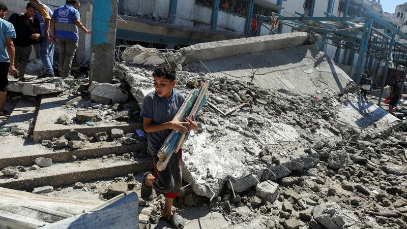 Warga Palestina memeriksa sekolah PBB yang menampung pengungsi, menyusul serangan Israel, di tengah konflik Israel-Hamas, di Nuseirat di Jalur Gaza tengah, 16 Juli 2024. (REUTERS/Ramadan Abed)