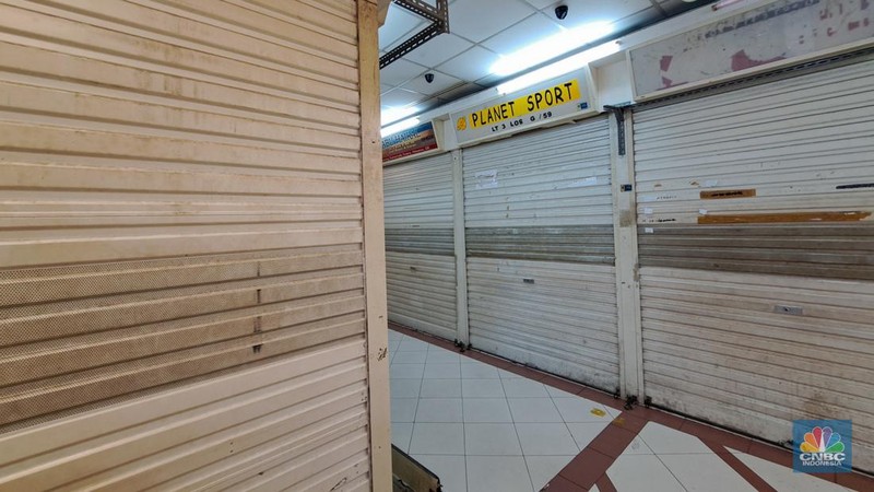 Penjual sepatu merapihkan dagangannya sebelum menutup toko di Blok A asar Tanah Abang, Jakarta, Kamis (18/7/2024). Sejumah pedagang Blok A Pasar Tanah Abang khususnya di lantai 3  Blok A mengaku tengah dilanda kepanikan karena khawtir akan adanya razia barang impor. (վ/Faisal Rahman)