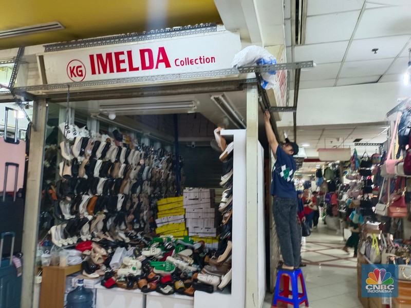 Penjual sepatu merapihkan dagangannya sebelum menutup toko di Blok A asar Tanah Abang, Jakarta, Kamis (18/7/2024). Sejumah pedagang Blok A Pasar Tanah Abang khususnya di lantai 3 Blok A mengaku tengah dilanda kepanikan karena khawtir akan adanya razia barang impor. Penjual sepatu merapihkan dagangannya sebelum menutup toko di Blok A asar Tanah Abang, Jakarta, Kamis (18/7/2024). Sejumah pedagang Blok A Pasar Tanah Abang khususnya di lantai 3 Blok A mengaku tengah dilanda kepanikan karena khawtir akan adanya razia barang impor. (CNBC Indonesia/Faisal Rahman)