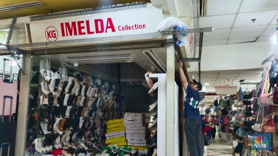 Penjual sepatu merapihkan dagangannya sebelum menutup toko di Blok A asar Tanah Abang, Jakarta, Kamis (18/7/2024). Sejumah pedagang Blok A Pasar Tanah Abang khususnya di lantai 3  Blok A mengaku tengah dilanda kepanikan karena khawtir akan adanya razia barang impor. (վ/Faisal Rahman)