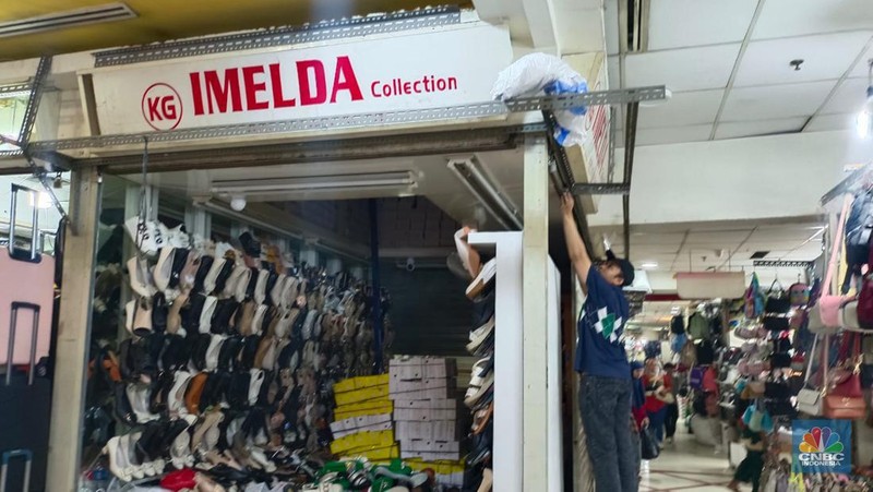 Penjual sepatu merapihkan dagangannya sebelum menutup toko di Blok A asar Tanah Abang, Jakarta, Kamis (18/7/2024). Sejumah pedagang Blok A Pasar Tanah Abang khususnya di lantai 3  Blok A mengaku tengah dilanda kepanikan karena khawtir akan adanya razia barang impor. (վ/Faisal Rahman)