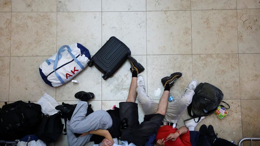 Seorang anak laki-laki tertidur di lantai saat para pelancong mengantri di Bandara Internasional Brussels di Brussels, Jumat, 19 Juli 2024. Pemadaman teknologi global membuat penerbangan terhenti, membuat bank dan sistem rumah sakit offline, dan outlet media tidak mengudara pada hari Jumat secara besar-besaran. (AP/Harry Nakos)