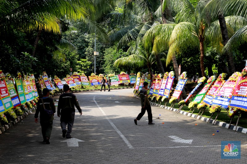 Pekerja merapikan karangan bunga berisi ucapan selamat untuk Wamentan Sudaryono di halaman Kementerian Pertanian (Kementan), Jakarta, Jumat (19/7/2024). (CNBC Indonesia/Muhammad Sabki)