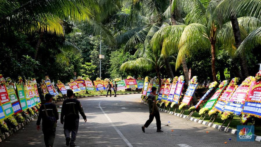 Pekerja merapikan karangan bunga berisi ucapan selamat untuk Wamentan Sudaryono di halaman Kementerian Pertanian (Kementan), Jakarta, Jumat (19/7/2024). (CNBC Indonesia/Muhammad Sabki)
