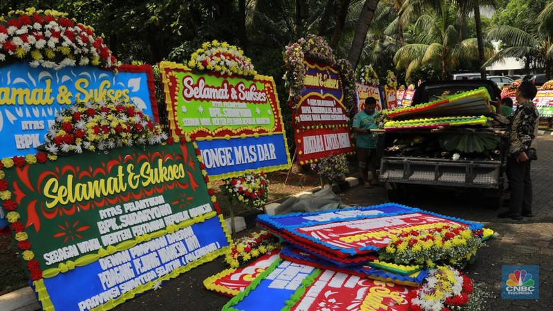 Pekerja merapikan karangan bunga berisi ucapan selamat untuk Wamentan Sudaryono di halaman Kementerian Pertanian (Kementan), Jakarta, Jumat (19/7/2024). (CNBC Indonesia/Muhammad Sabki)