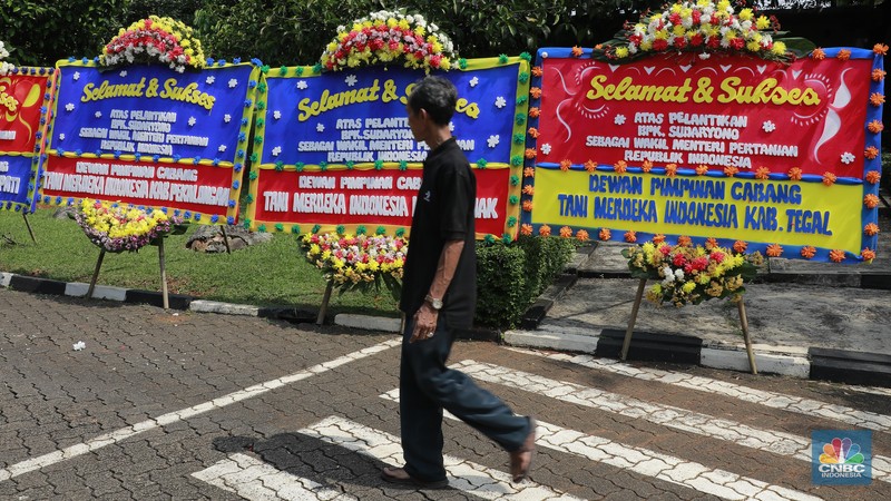 Pekerja merapikan karangan bunga berisi ucapan selamat untuk Wamentan Sudaryono di halaman Kementerian Pertanian (Kementan), Jakarta, Jumat (19/7/2024). (CNBC Indonesia/Muhammad Sabki)