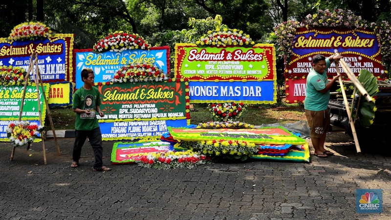 Pekerja merapikan karangan bunga berisi ucapan selamat untuk Wamentan Sudaryono di halaman Kementerian Pertanian (Kementan), Jakarta, Jumat (19/7/2024). (CNBC Indonesia/Muhammad Sabki)