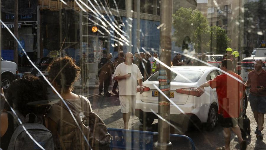 Personel darurat Israel memeriksa puing-puing di dekat apartemen di Tel Aviv yang dihantam serangan drone Houthi. (AP Photo/Oded Balilty)