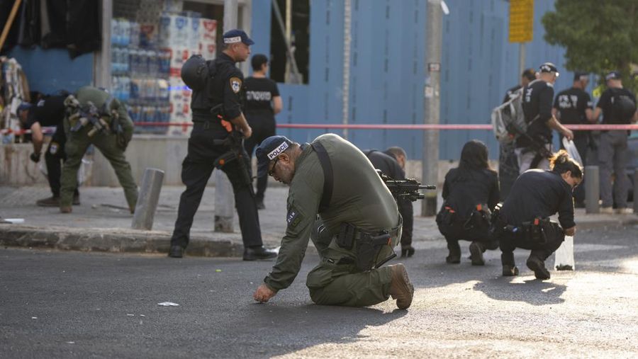Personel darurat Israel memeriksa puing-puing di dekat apartemen di Tel Aviv yang dihantam serangan drone Houthi. (AP Photo/Oded Balilty)