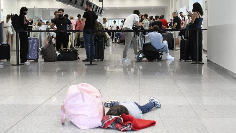 Seorang anak laki-laki tertidur di lantai saat para pelancong mengantri di Bandara Internasional Brussels di Brussels, Jumat, 19 Juli 2024. Pemadaman teknologi global membuat penerbangan terhenti, membuat bank dan sistem rumah sakit offline, dan outlet media tidak mengudara pada hari Jumat secara besar-besaran. (AP/Harry Nakos)