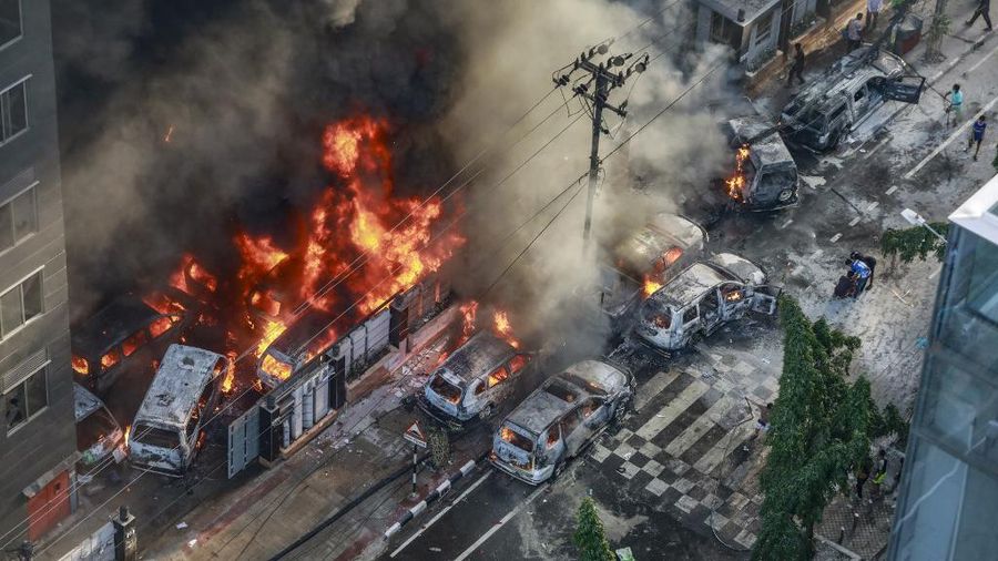 Asap mengepul dari kendaraan yang terbakar setelah pengunjuk rasa membakarnya kantor Direktorat Penanggulangan Bencana, selama protes anti-kuota yang sedang berlangsung di Dhaka pada 18 Juli 2024. (AFP/-)