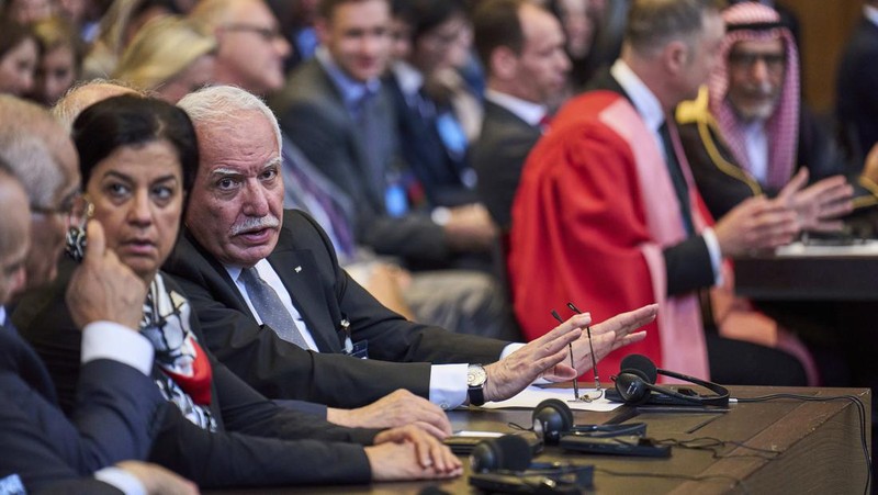 Penasihat kebijakan luar negeri Palestina Riad Malki bertemu dengan salah satu anggota tim Israel sebelum hakim memasuki Mahkamah Internasional, atau Pengadilan Dunia, di Den Haag, Belanda, Jumat 19 Juli 2024. (AP/Phil Nijhuis)