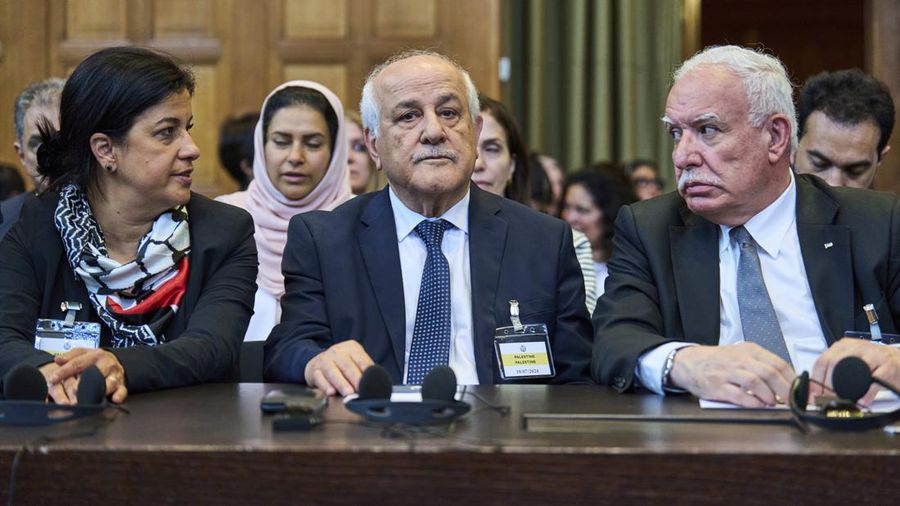 Penasihat kebijakan luar negeri Palestina Riad Malki bertemu dengan salah satu anggota tim Israel sebelum hakim memasuki Mahkamah Internasional, atau Pengadilan Dunia, di Den Haag, Belanda, Jumat 19 Juli 2024. (AP/Phil Nijhuis)