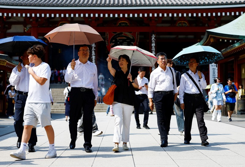 Pejalan kaki yang memegang payung berjalan di bawah sinar matahari yang terik di kuil Sensoji saat pemerintah Jepang mengeluarkan peringatan serangan panas di 39 dari 47 prefektur di Tokyo, Jepang, 22 Juli 2024. Pejalan kaki yang memegang payung berjalan di bawah sinar matahari yang terik di kuil Sensoji saat pemerintah Jepang mengeluarkan peringatan serangan panas di 39 dari 47 prefektur di Tokyo, Jepang, 22 Juli 2024. (REUTERS/Issei Kato)
