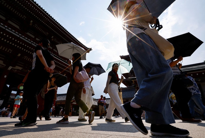 Pejalan kaki yang memegang payung berjalan di bawah sinar matahari yang terik di kuil Sensoji saat pemerintah Jepang mengeluarkan peringatan serangan panas di 39 dari 47 prefektur di Tokyo, Jepang, 22 Juli 2024. Pejalan kaki yang memegang payung berjalan di bawah sinar matahari yang terik di kuil Sensoji saat pemerintah Jepang mengeluarkan peringatan serangan panas di 39 dari 47 prefektur di Tokyo, Jepang, 22 Juli 2024. (REUTERS/Issei Kato)