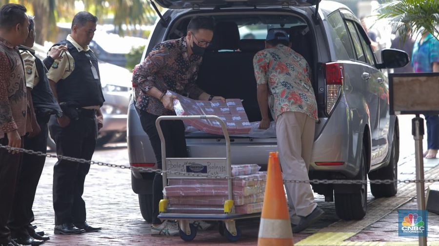 Petugas kejakasaan memindahkan uang barang bukti terkait kasus korupsi IUP PT Timah di Kejaksaan Negeri Jakarta Selatan, Senin (22/7/2024). (CNBC Indonesia/Faisal Rahman)