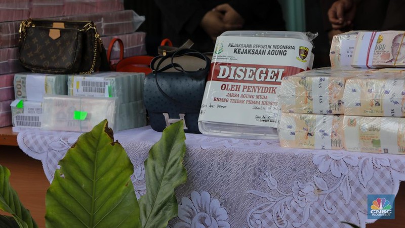 Petugas kejakasaan memindahkan uang barang bukti terkait kasus korupsi IUP PT Timah di Kejaksaan Negeri Jakarta Selatan, Senin (22/7/2024). (CNBC Indonesia/Faisal Rahman)