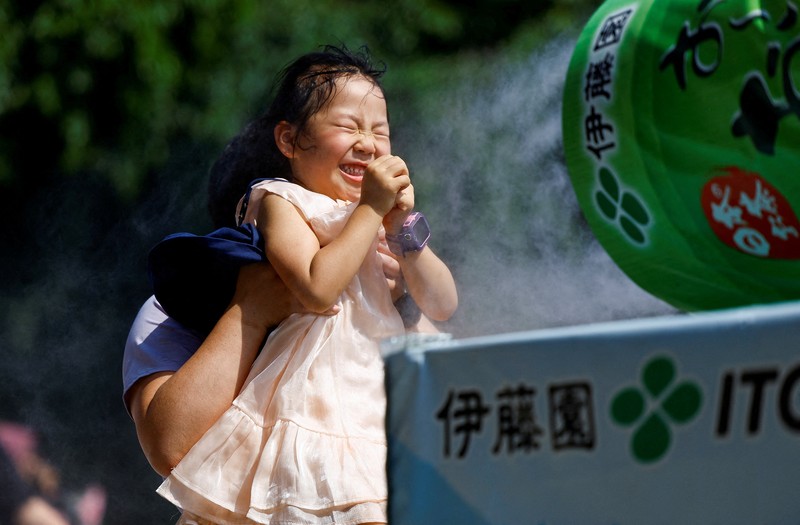 Pejalan kaki yang memegang payung berjalan di bawah sinar matahari yang terik di kuil Sensoji saat pemerintah Jepang mengeluarkan peringatan serangan panas di 39 dari 47 prefektur di Tokyo, Jepang, 22 Juli 2024. (REUTERS/Issei Kato)