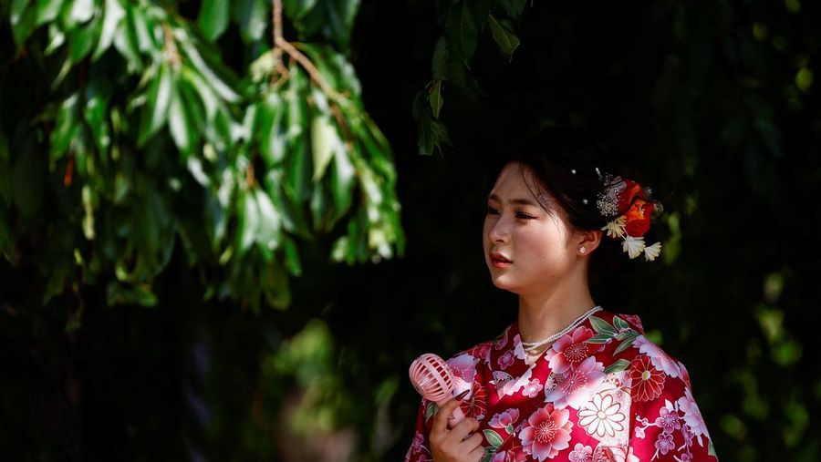 Pejalan kaki yang memegang payung berjalan di bawah sinar matahari yang terik di kuil Sensoji saat pemerintah Jepang mengeluarkan peringatan serangan panas di 39 dari 47 prefektur di Tokyo, Jepang, 22 Juli 2024. (REUTERS/Issei Kato)