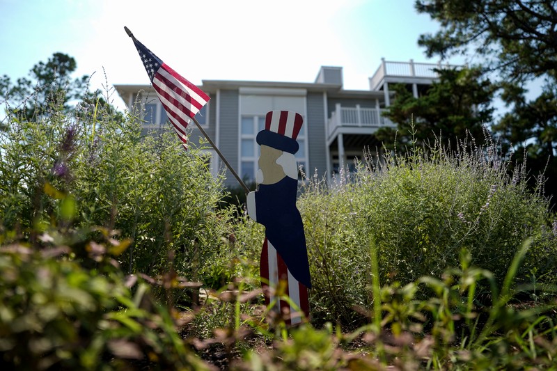 People at a restaurant called Somewhere look at a TV where U.S. President Joe Biden can be seen, on the day he announced he is stopping his bid for reelection, in Rehoboth Beach, Delaware, U.S., July 21, 2024. REUTERS/Ken Cedeno