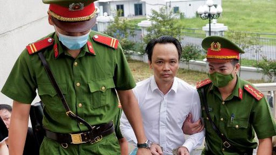 Chairman of FLC group Trinh Van Quyet (C) is escorted by policemen to a court for his trial on fraud charges in Hanoi on July 22, 2024. Vietnamese property and aviation tycoon Trinh Van Quyet faced justice in Hanoi on July 22 as authorities asserting their iron fist on wrongdoings among the business community. (Photo by Anh TUC / AFP)