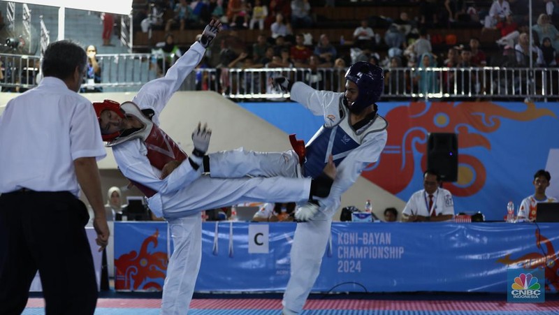 Atlet taekwondo berlaga dalam Ajang turnamen rangkaian Road to PON XXI, KONI-Bayan Championship 2024 di Universitas Mulawarman (Unmul) Samarinda, Kalimantan Timur, Selasa (23/7/2024). (CNBC Indonesia/Tri Susilo)