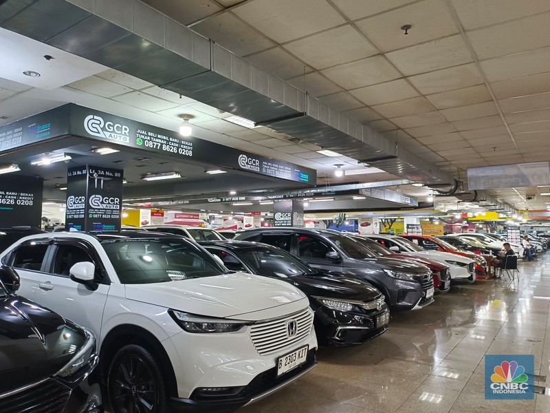 Seorang pengunjung melihat mobil-mobil bekas yang dijual di Mangga Dua Square pada Senin (22/7/2024). (CNBC Indonesia/Martyasari Rizky)