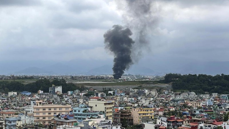 Asap mengepul dari Bandara Internasional Tribhuvan di Kathmandu, Nepal, Rabu, 24 Juli 2024. Televisi pemerintah di Nepal melaporkan sebuah pesawat tergelincir dari landasan dan jatuh saat mencoba lepas landas dari bandara Kathmandu. (AP Photo/Agniia Galdanova)