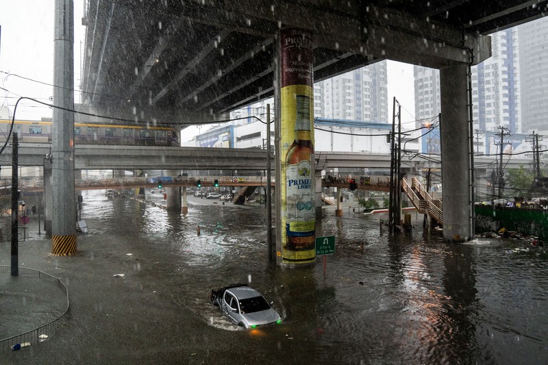 ASIA-WEATHER/PHILIPPINES A car wades through a flooded road following heavy rains brought by Typhoon Gaemi, in Manila, Philippines, July 24, 2024. REUTERS/Lisa Marie David