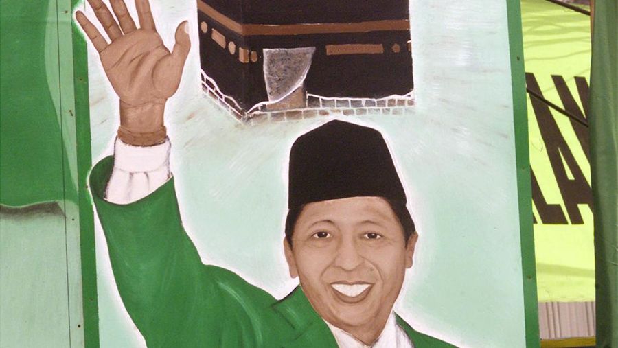 INDONESIA ELECTIONS A United Development Party supporter stands in front of a picture of Indonesian Vice President Hamzah Haz, during a campaign rally, Friday, March 19, 2004, in Jakarta, Indonesia. Indonesia's parliamentary elections will be held on April 5 of this year. (AP Photo/Tatan Syuflana)