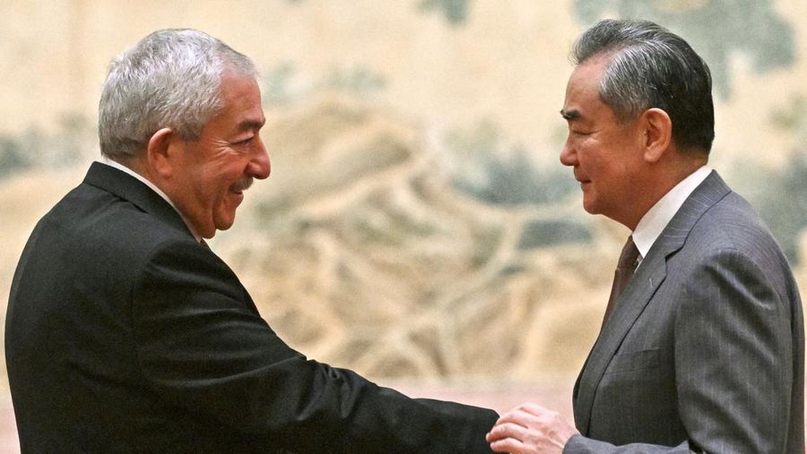 China's Foreign Minister Wang Yi looks on during the signing of the 