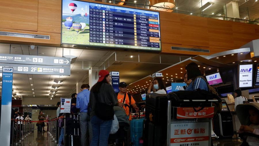 Orang-orang mengantri di dekat layar yang menampilkan informasi penerbangan di aula keberangkatan internasional Bandara Songshan Taipei saat Topan Gaemi mendekat di Taipei, Taiwan 24 Juli 2024. (REUTERS/Carlos Garcia Rawlins)
