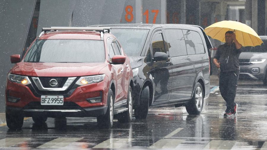 Orang-orang mengantri di dekat layar yang menampilkan informasi penerbangan di aula keberangkatan internasional Bandara Songshan Taipei saat Topan Gaemi mendekat di Taipei, Taiwan 24 Juli 2024. (REUTERS/Carlos Garcia Rawlins)