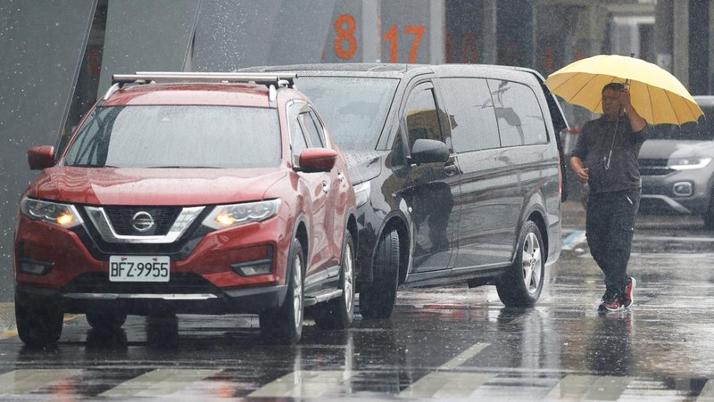 Orang-orang mengantri di dekat layar yang menampilkan informasi penerbangan di aula keberangkatan internasional Bandara Songshan Taipei saat Topan Gaemi mendekat di Taipei, Taiwan 24 Juli 2024. (REUTERS/Carlos Garcia Rawlins)