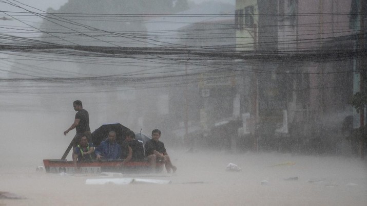 Tim penyelamat membantu warga di atas perahu di sepanjang jalan yang banjir menyusul hujan lebat yang dibawa oleh Topan Gaemi, di Kota Marikina, Metro Manila, Filipina, 24 Juli 2024. (REUTERS/Lisa Marie David)